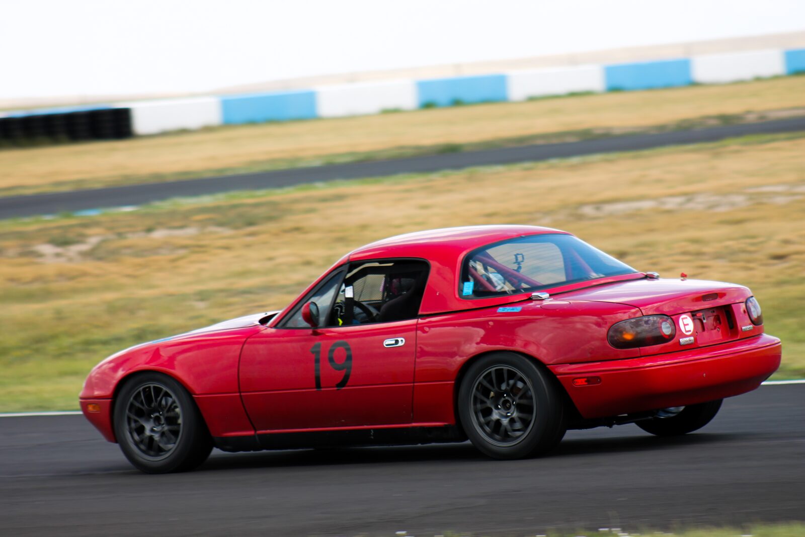 A red Mazda MX-5 cornering on track
